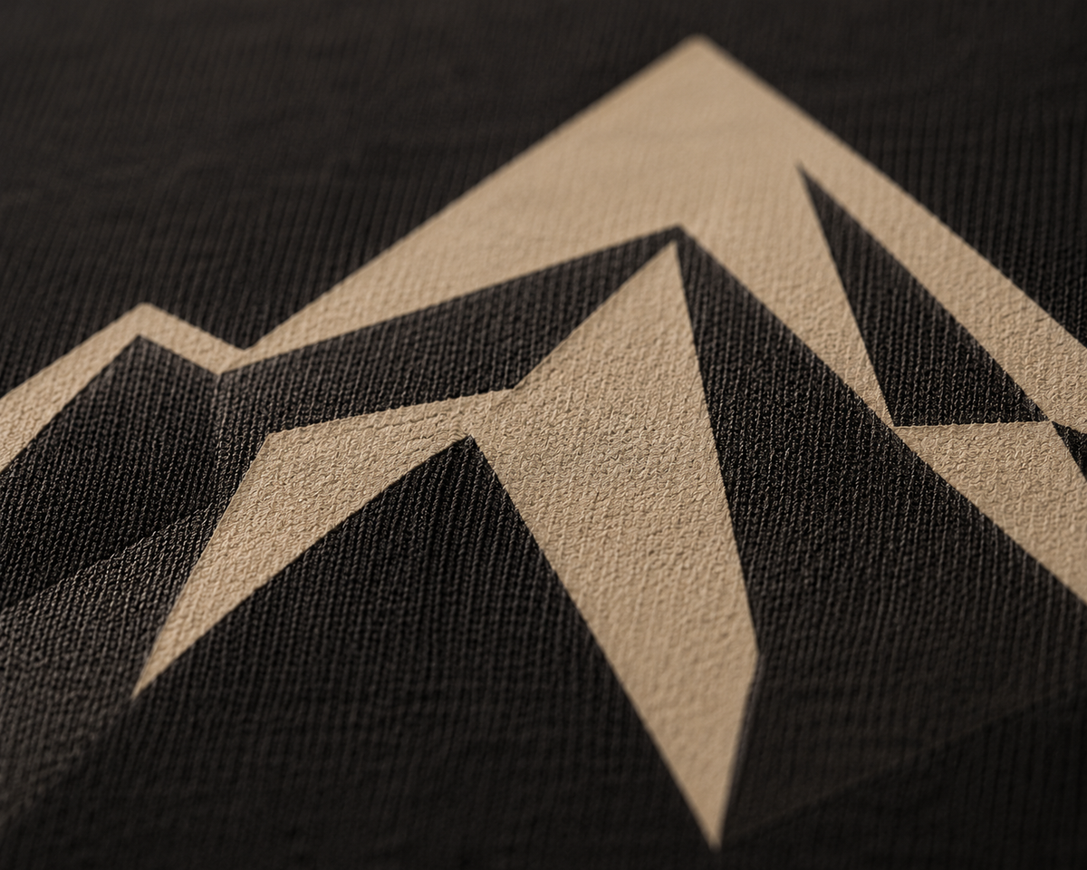 Macro detail of the sand screen print on near-black cotton jersey