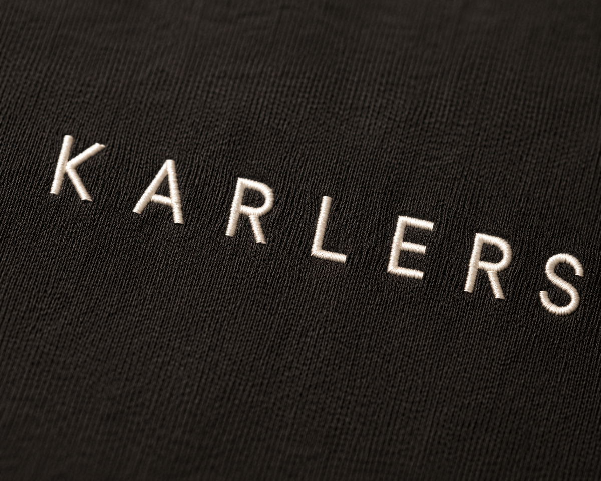 Close-up of bone embroidery on near-black cotton jersey