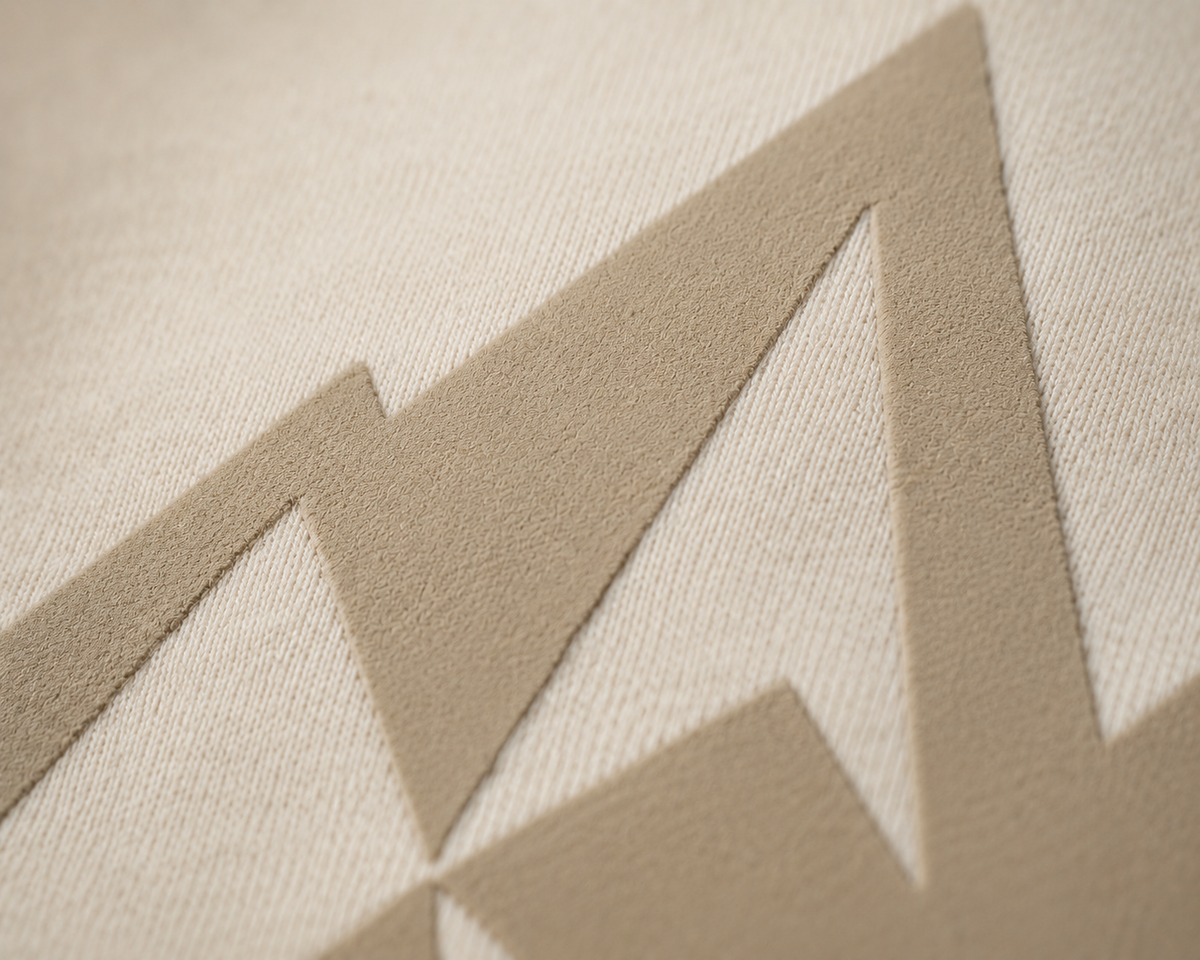 Macro detail of the sand screen print on bone fleece showing the knit texture